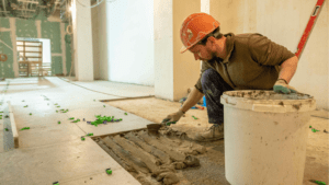 Trabajador colocando suelo durante reforma integral de vivienda