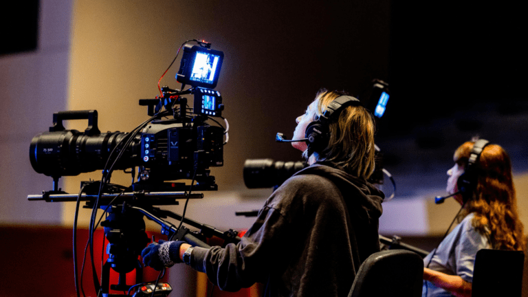Operadora de cámara profesional grabando un cortometraje con equipo de cine en estudio de producción audiovisual en Barcelona.