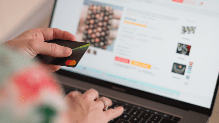 Persona comprando online con tarjeta en una tienda digital personalizada desde un portátil.