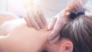 Terapia de acupuntura en la espalda aplicada por especialista para aliviar migrañas y cefaleas tensionales.