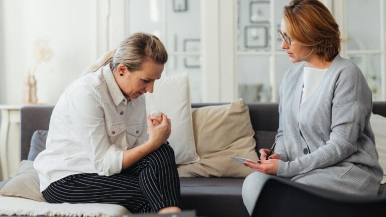 Mujer sentada con expresión triste reflexionando sobre su relación tóxica, en un espacio tranquilo que transmite necesidad de apoyo emocional y sanación