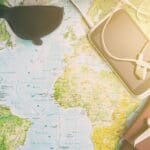 Persona revisando calendario, mapas y clima para elegir la mejor época del año para viajar, combinando presupuesto, destino y experiencias deseadas