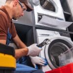 Técnico revisando lavadora que no desagua en casa, reparación de electrodomésticos en Tarragona.