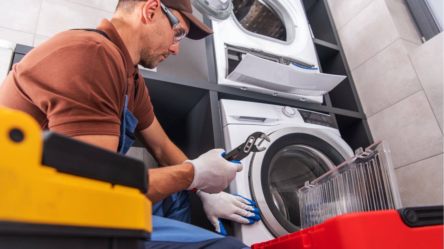 Técnico revisando lavadora que no desagua en casa, reparación de electrodomésticos en Tarragona.
