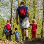 Familia disfrutando de actividades rurales al aire libre durante una escapada en la naturaleza