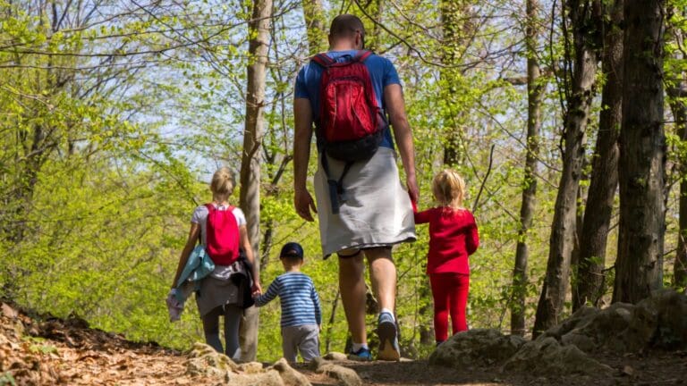Familia disfrutando de actividades rurales al aire libre durante una escapada en la naturaleza