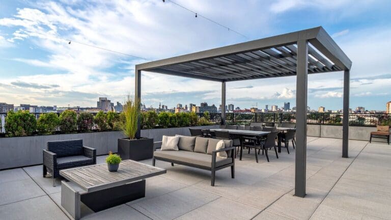 Pérgola bioclimática moderna instalada en una terraza con mobiliario de exterior, ideal para proteger del sol y la lluvia durante todo el año.