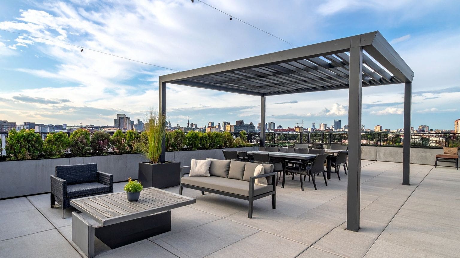 Pérgola bioclimática moderna instalada en una terraza con mobiliario de exterior, ideal para proteger del sol y la lluvia durante todo el año.