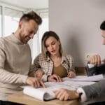 Cliente analizando planos con un arquitecto para evitar errores comunes antes de iniciar un proyecto en Barcelona