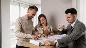 Cliente analizando planos con un arquitecto para evitar errores comunes antes de iniciar un proyecto en Barcelona