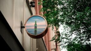 Cartel publicitario metálico de alta calidad instalado en fachada comercial, ideal para destacar una marca con imagen profesional y duradera