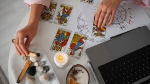 Mujer preparando su energía antes de una lectura de tarot en un espacio espiritual con cartas, velas y cristales
