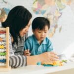 Niño en edad infantil concentrado mientras juega y explora en un entorno educativo, como parte del desarrollo cognitivo temprano.