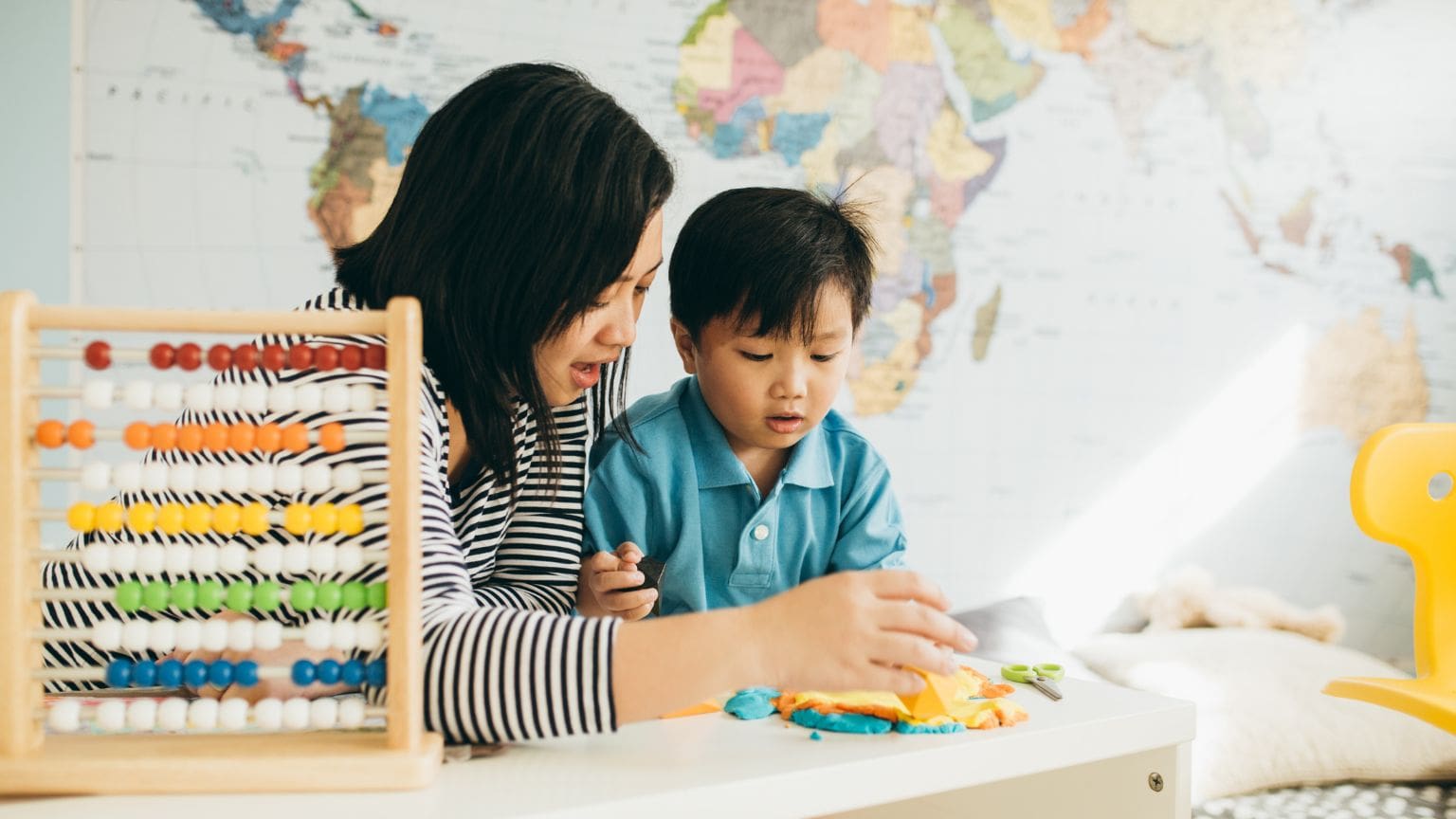 Niño en edad infantil concentrado mientras juega y explora en un entorno educativo, como parte del desarrollo cognitivo temprano.
