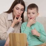 Niño pequeño practicando sonidos con apoyo de logopeda en casa