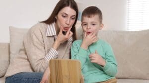 Niño pequeño practicando sonidos con apoyo de logopeda en casa