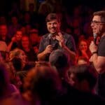 Artista de espectáculo de improvisación conectando con el público durante una actuación en vivo llena de humor escénico y participación