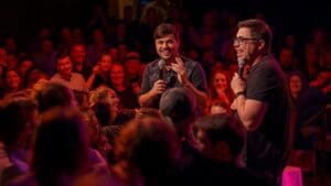 Artista de espectáculo de improvisación conectando con el público durante una actuación en vivo llena de humor escénico y participación