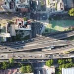Vista aérea de intersección urbana con autopistas y calles que refleja la importancia de estudios de tráfico y movilidad en proyectos urbanos