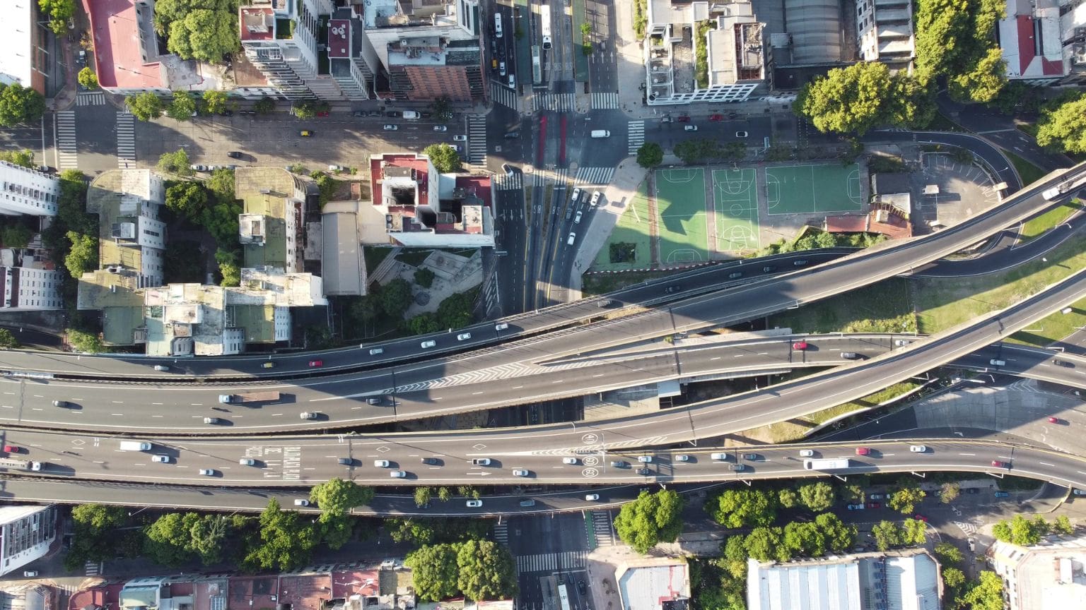 Vista aérea de intersección urbana con autopistas y calles que refleja la importancia de estudios de tráfico y movilidad en proyectos urbanos