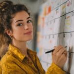 Emprendedora organizando su estrategia de contenido en redes sociales con calendario digital y ordenador portátil