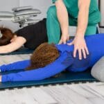 Mujer realizando pilates terapéutico supervisado en clínica especializada