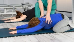 Mujer realizando pilates terapéutico supervisado en clínica especializada