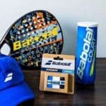 Accesorios de pádel organizados en paletero sobre banco deportivo antes de un partido