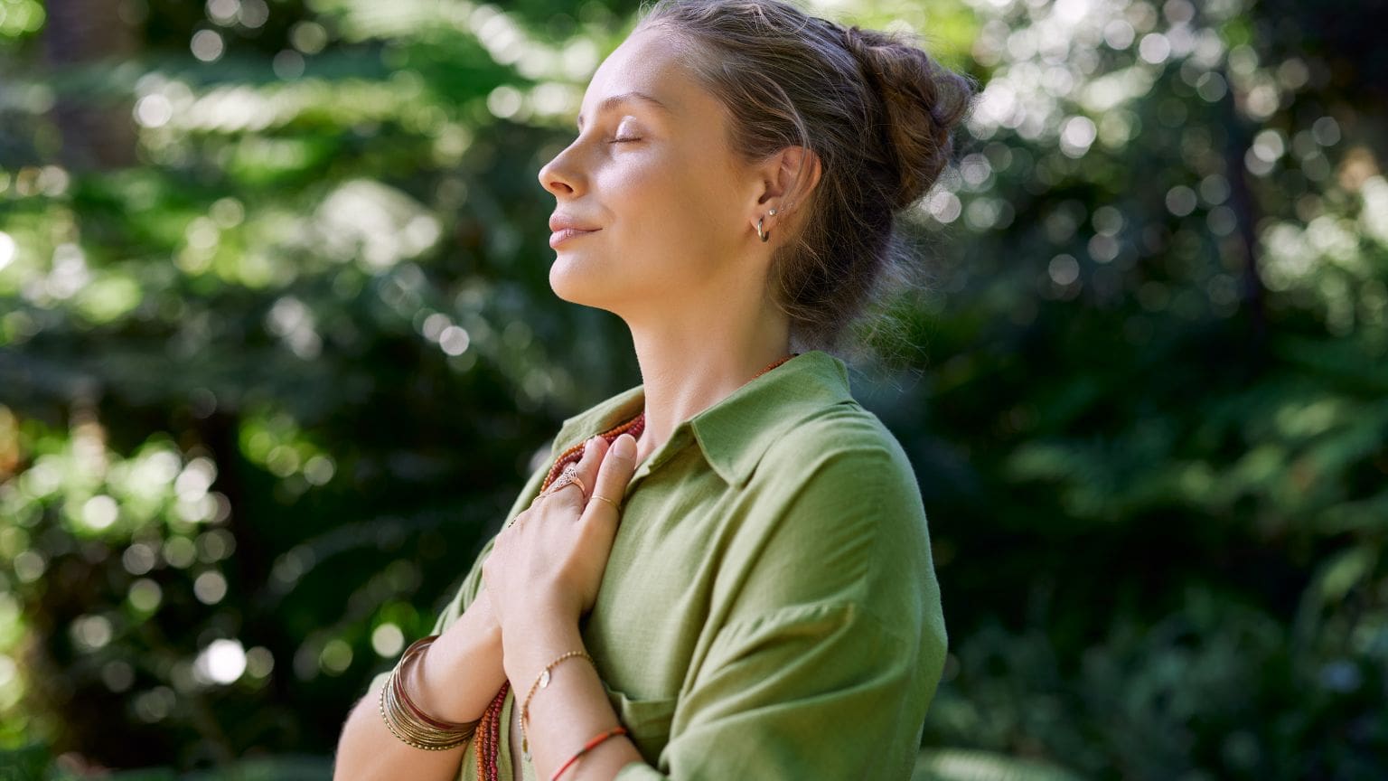 Mujer en medio de la naturaleza viviendo una experiencia transformadora a nivel físico, mental y espiritual