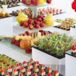 Mesa de catering variado con opciones dulces, saladas, veganas y sin gluten para diferentes tipos de invitados en eventos