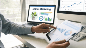 Esquema visual sobre qué es una estrategia de marketing digital con equipo trabajando en laptops, gráficos y notas en una mesa de oficina.