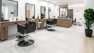 Interior moderno de un salón de belleza con clienta recibiendo atención personalizada.