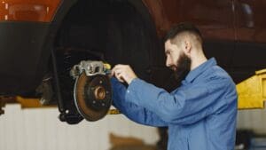 Mecánico cambiando pastillas de freno en coche para mejorar la seguridad