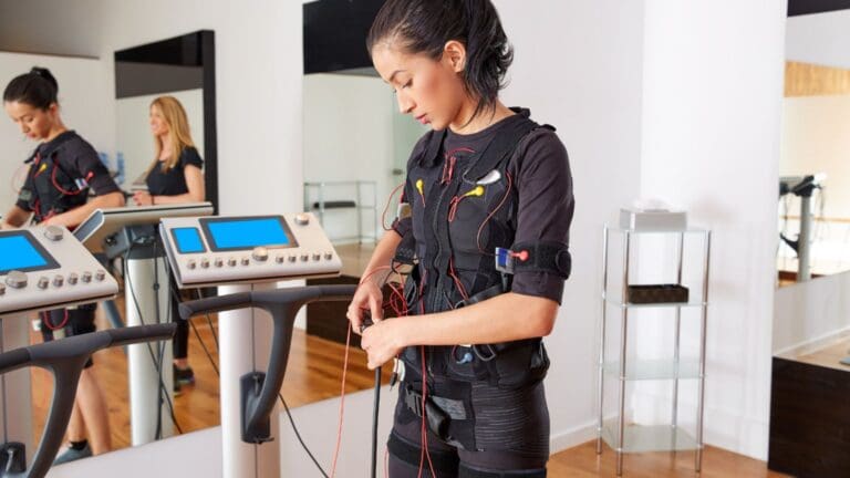 Mujer entrenando con traje de electroestimulación para perder grasa y tonificar el cuerpo sin levantar pesas