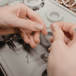 Detalle de joyas artesanales sobre una superficie natural y cálida.