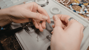 Detalle de joyas artesanales sobre una superficie natural y cálida.