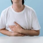 Niño con dolor de barriga acompañado de su madre en una consulta médica pediátrica