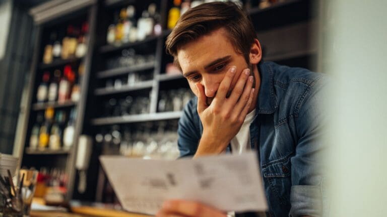 Empleado preocupado revisando su nómina por impago o retraso de salario en el entorno laboral