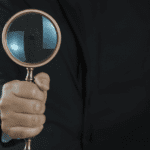 Detective privado para empresas analizando documentos en oficina corporativa.