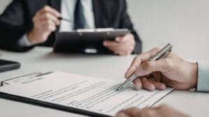 Empresarios firmando contratos mercantiles en reunión profesional