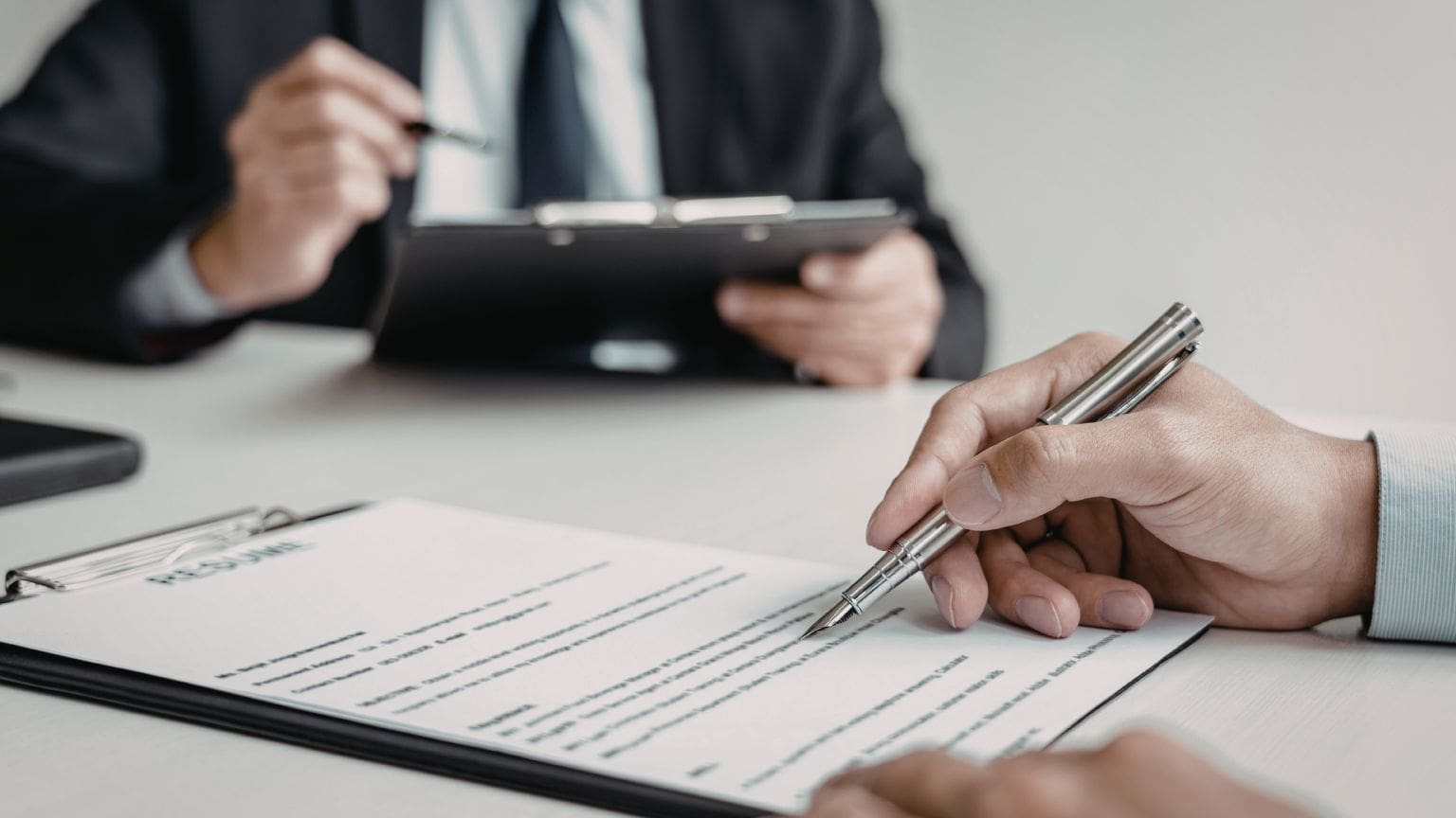 Empresarios firmando contratos mercantiles en reunión profesional