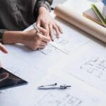 dirección de obra supervisando un proyecto de reforma residencial con planos arquitectónicos sobre la mesa