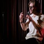 Persona recitando poesía en un evento de Poetry Slam frente a un público