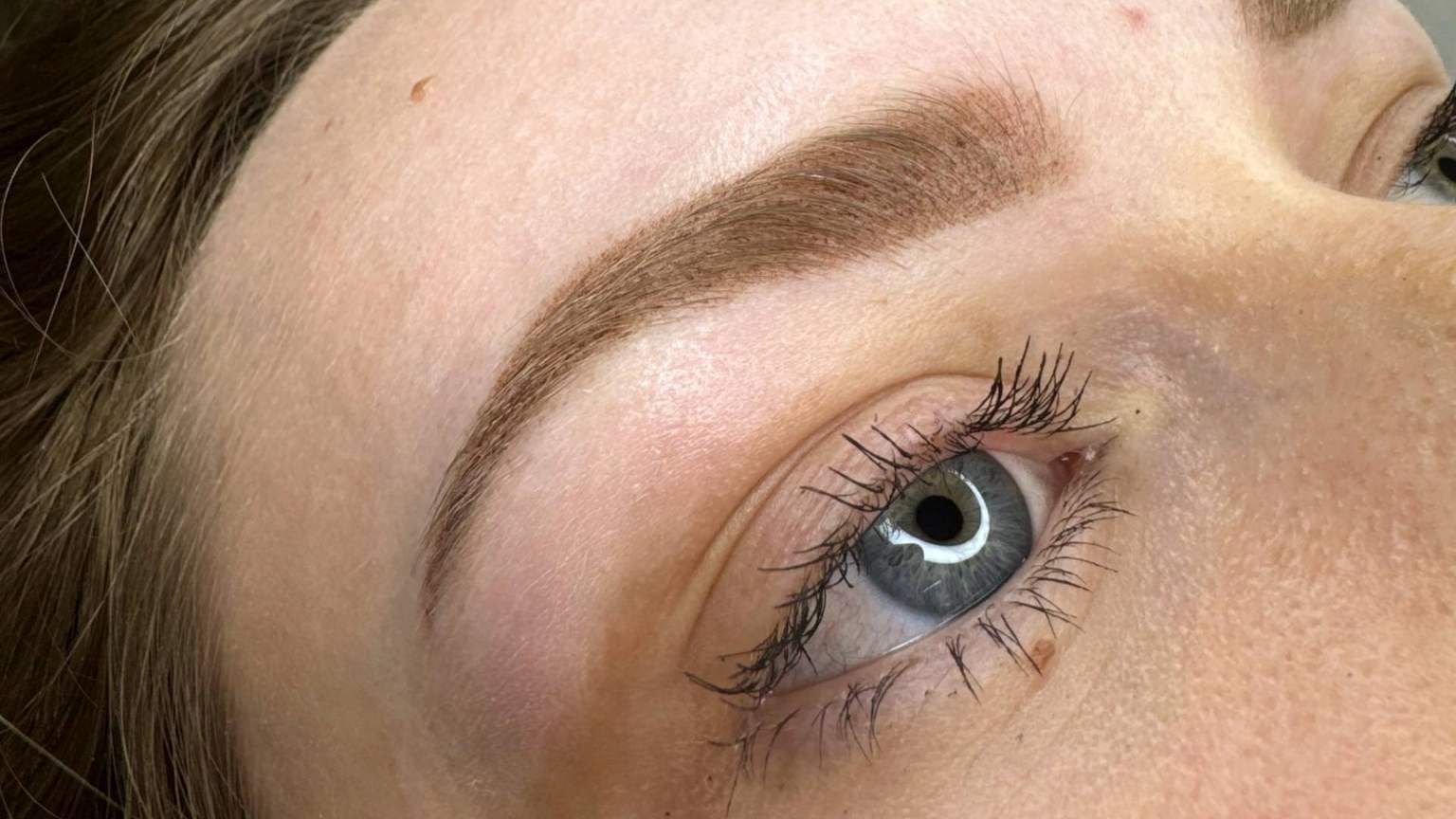 Especialista realizando micropigmentación de cejas en Barcelona con técnica pelo a pelo.