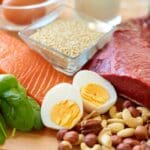 nutrición natural con alimentos frescos como salmón, huevos, frutos secos y verduras para mejorar el bienestar