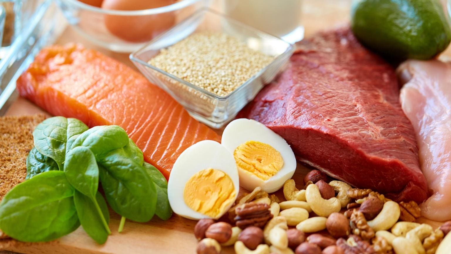 nutrición natural con alimentos frescos como salmón, huevos, frutos secos y verduras para mejorar el bienestar