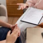 Agente de seguros asesorando a una familia sobre póliza de protección y planificación financiera en el hogar