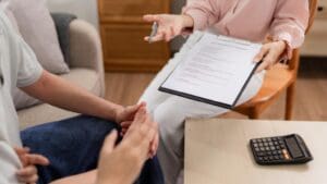 Agente de seguros asesorando a una familia sobre póliza de protección y planificación financiera en el hogar