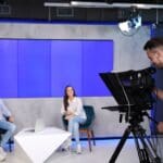 Rodaje de vídeo corporativo con luces y trípode en entorno empresarial.