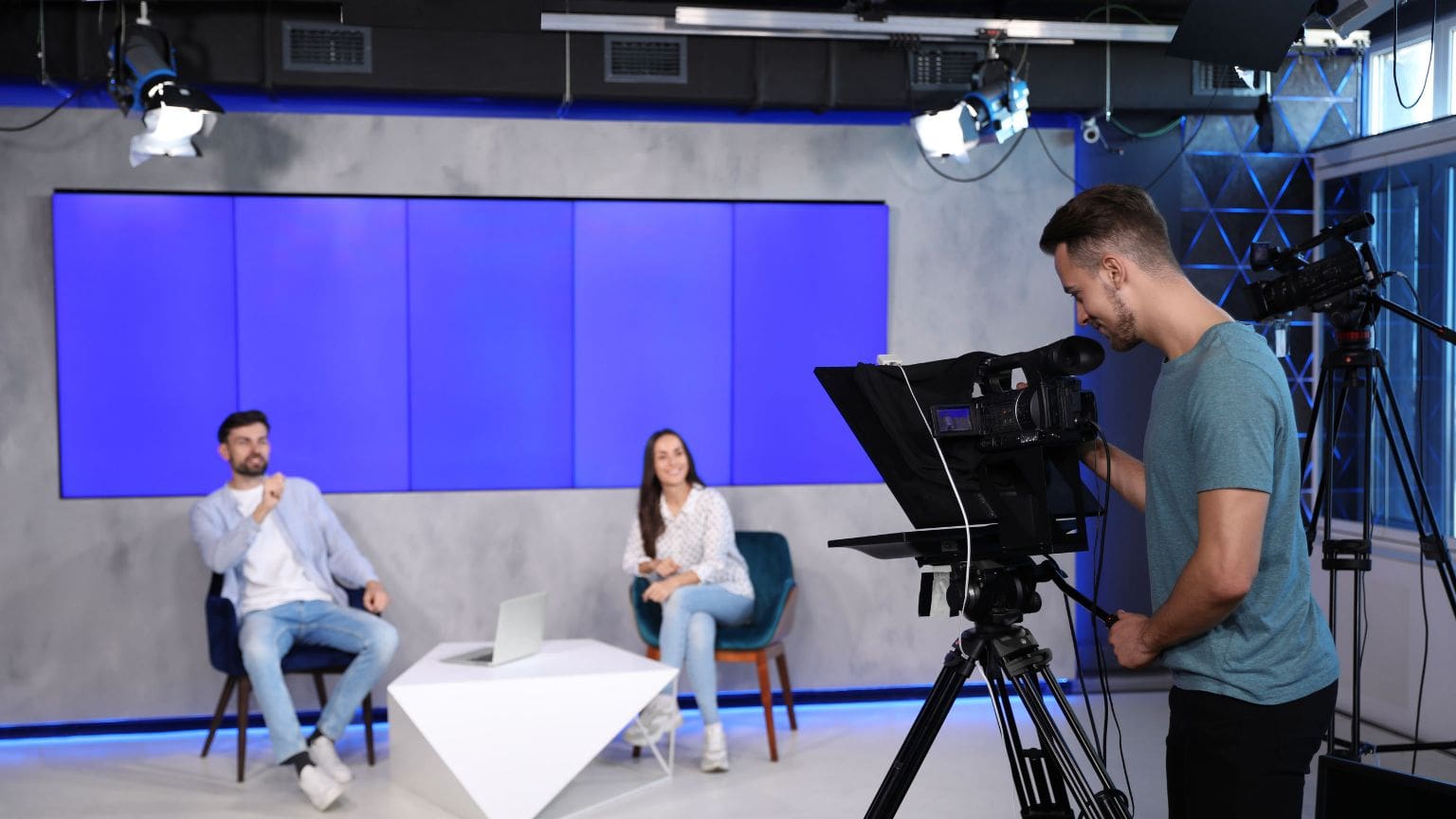 Rodaje de vídeo corporativo con luces y trípode en entorno empresarial.